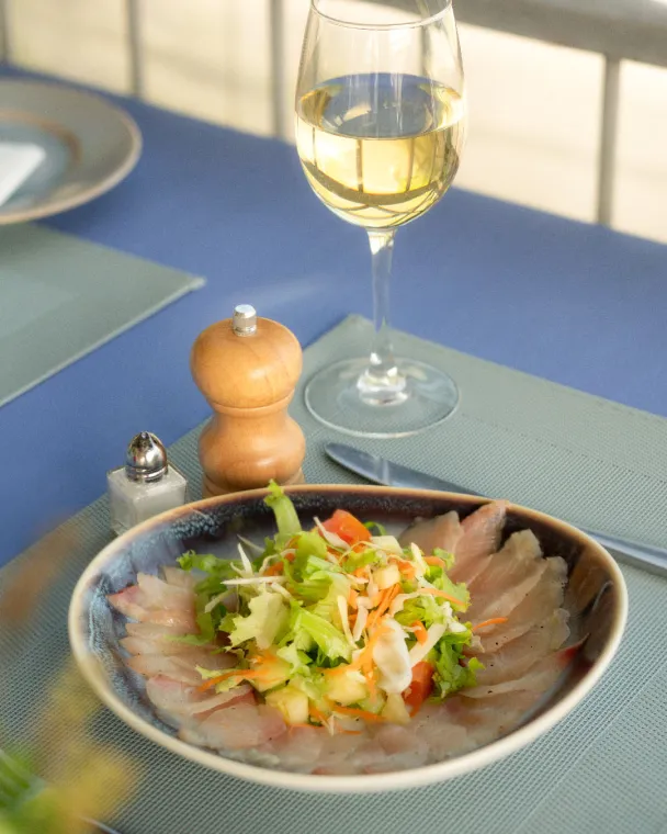 poisson mariné servi avec un verre de vin blanc
