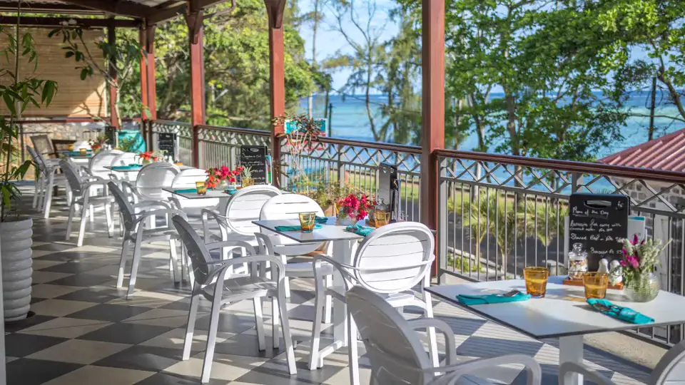 Under the veranda, tables set facing the lagoon